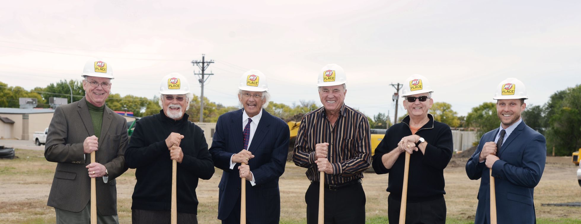 Six of My Place Hotel's corporate team members breaking ground with shovels and hard hats
